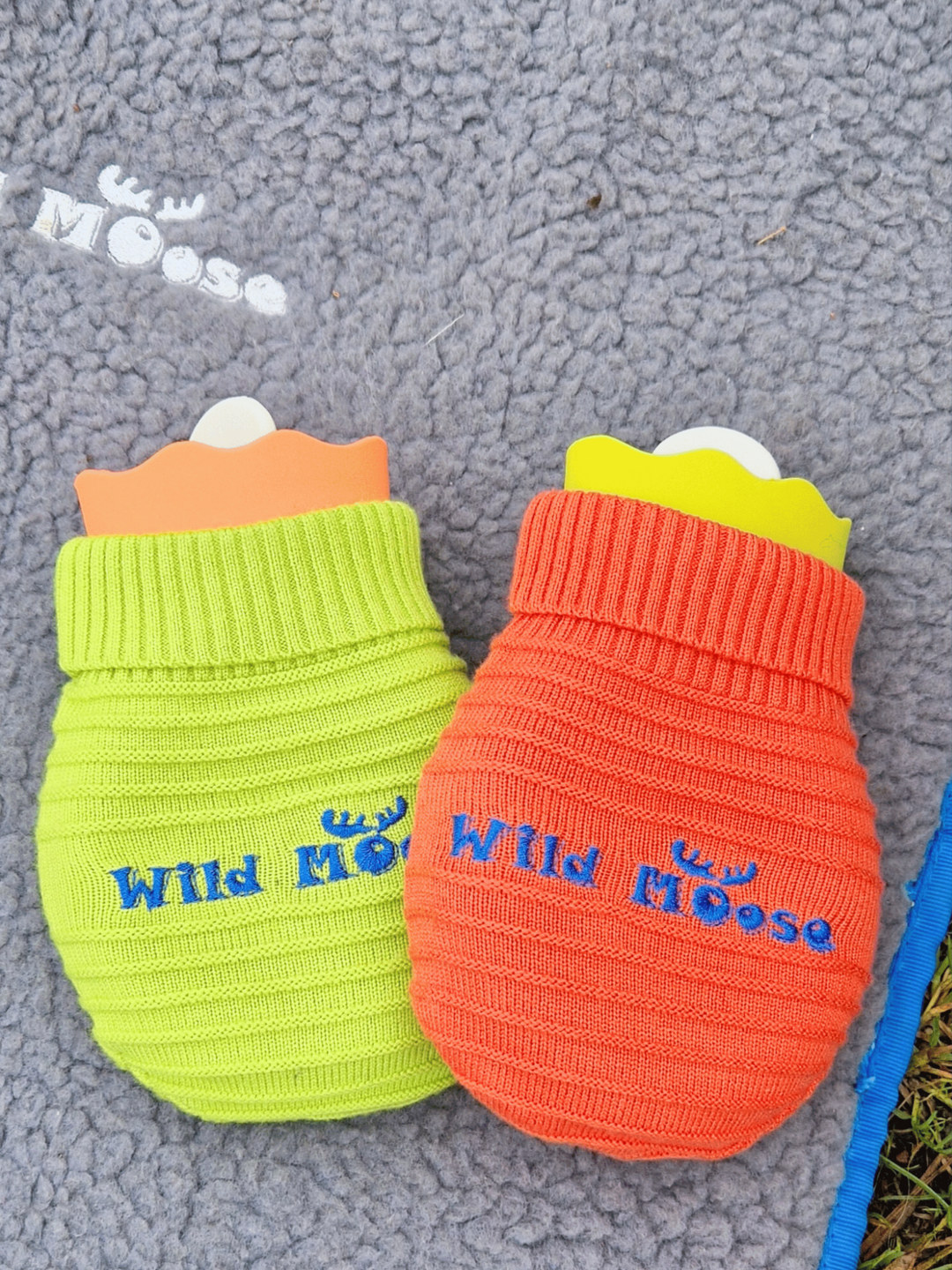 brightly coloured mini hot water bottles in a knitted cover in orange and lime green