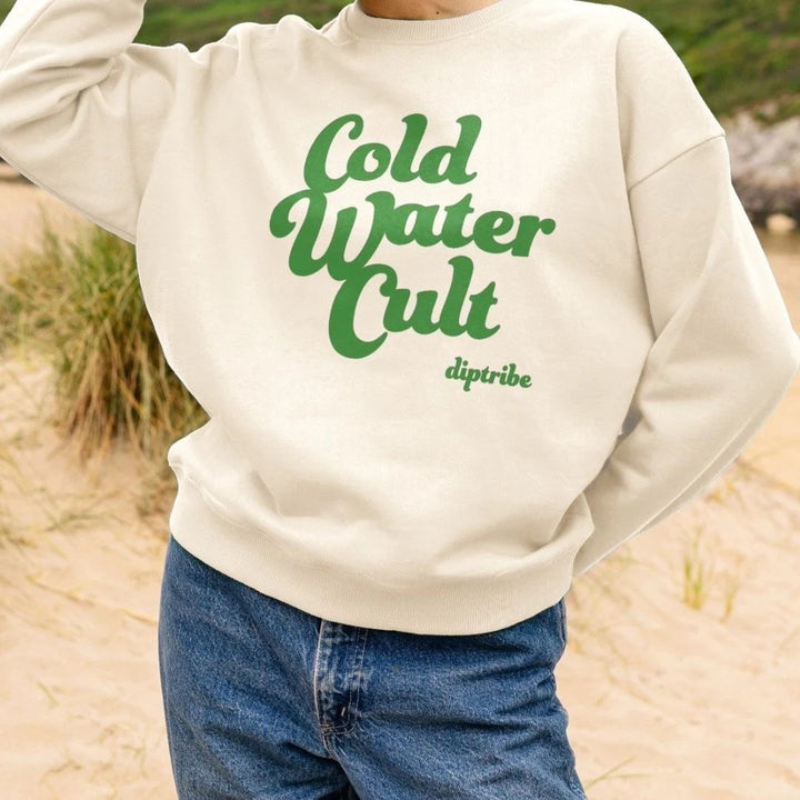 Person wearing a diptribe oat sweatshirt with 'Cold Water Cult'  written in a green  large font on the front