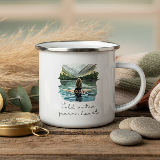 Mug with a design of a person swimming in a lake with mountains and the text 'Cold water fierce heart' on a white background.