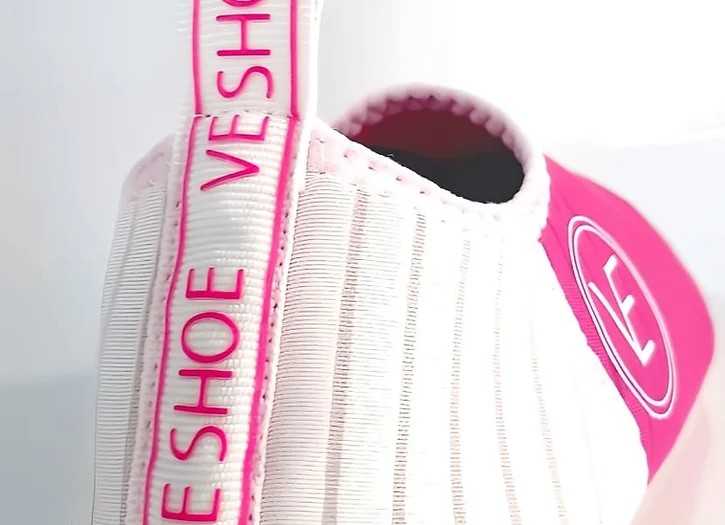 Flat shot of a pair of hot pink water shoes showing the VE Shoe label on the back