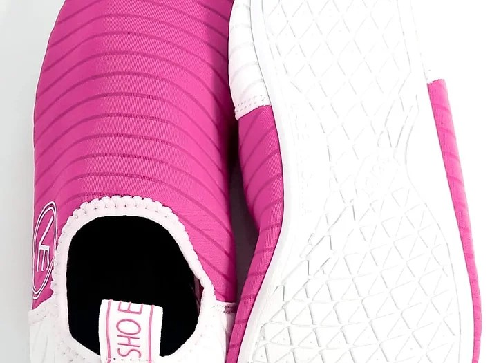 Flat shot of a pair of hot pink VE Shoe water shoes showing the white sole