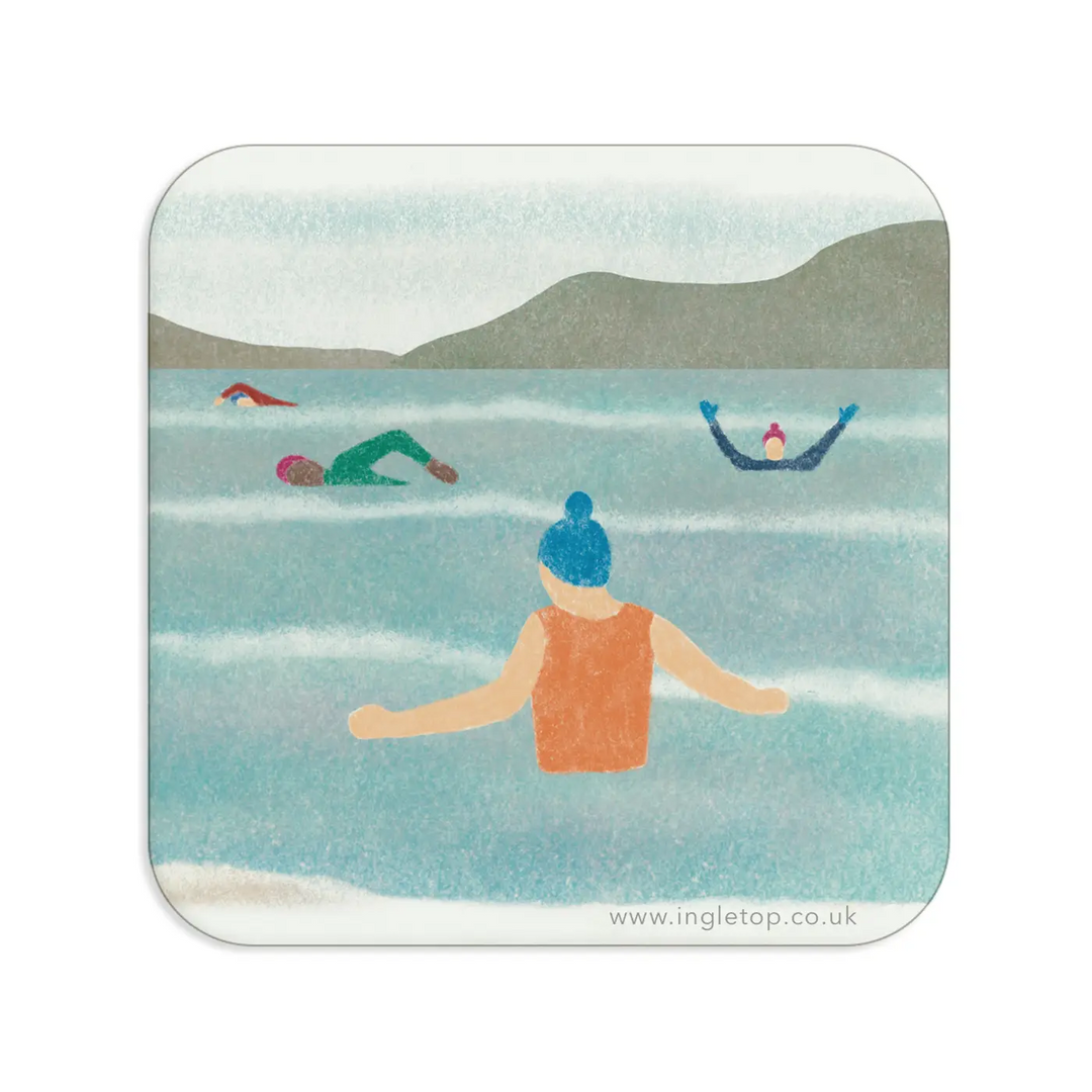 Coaster with an illustration of a group of people wild swimming in an outdoor body of water, with a mountainous landscape in the background. 