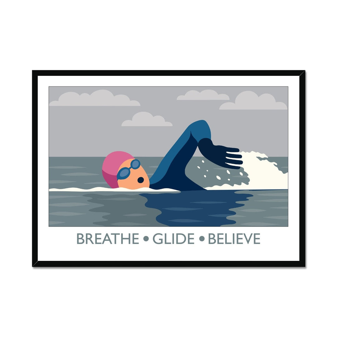 Framed wild swimming art print in black frame showing open water swimmer mid-stroke titled Breathe Glide Believe