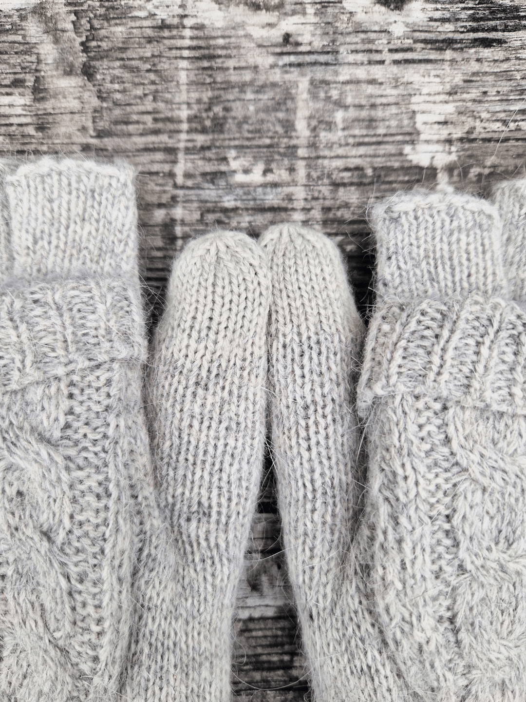 Close-up of gray knitted gloves with a textured background