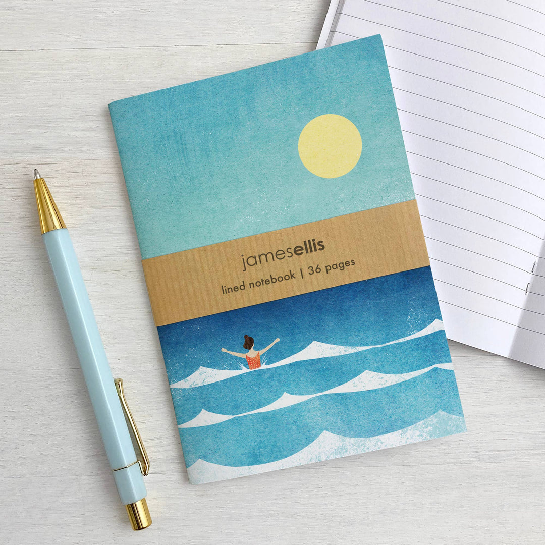 Dip in the Sea A6 notebook by Henry Rivers displayed beside an open notebook and pen.
