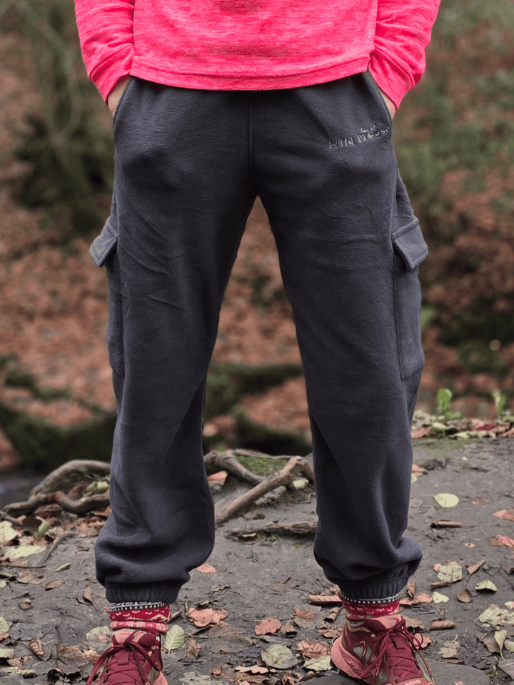 Person wearing dark grey fleece jogging pants, with hands in side pockets