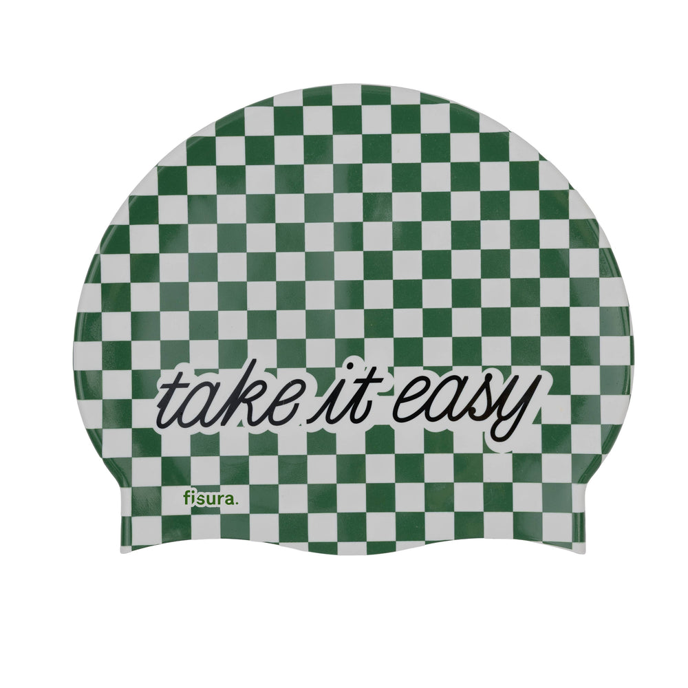 A green and white checkered swim cap with the words 'take it easy' printed in black script on a white background