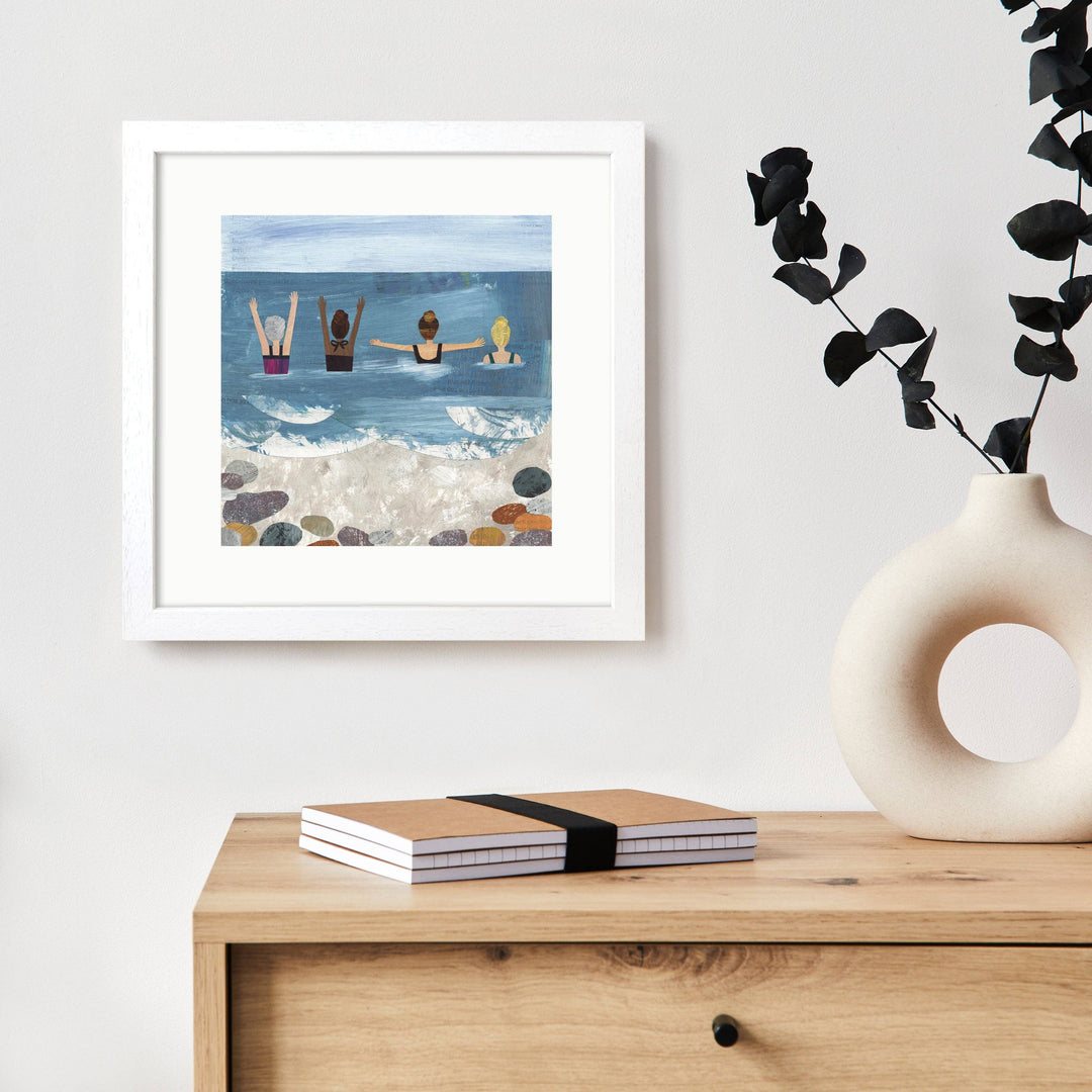Wild Sea Swimmers art print displayed in a white frame in a contemporary home setting.