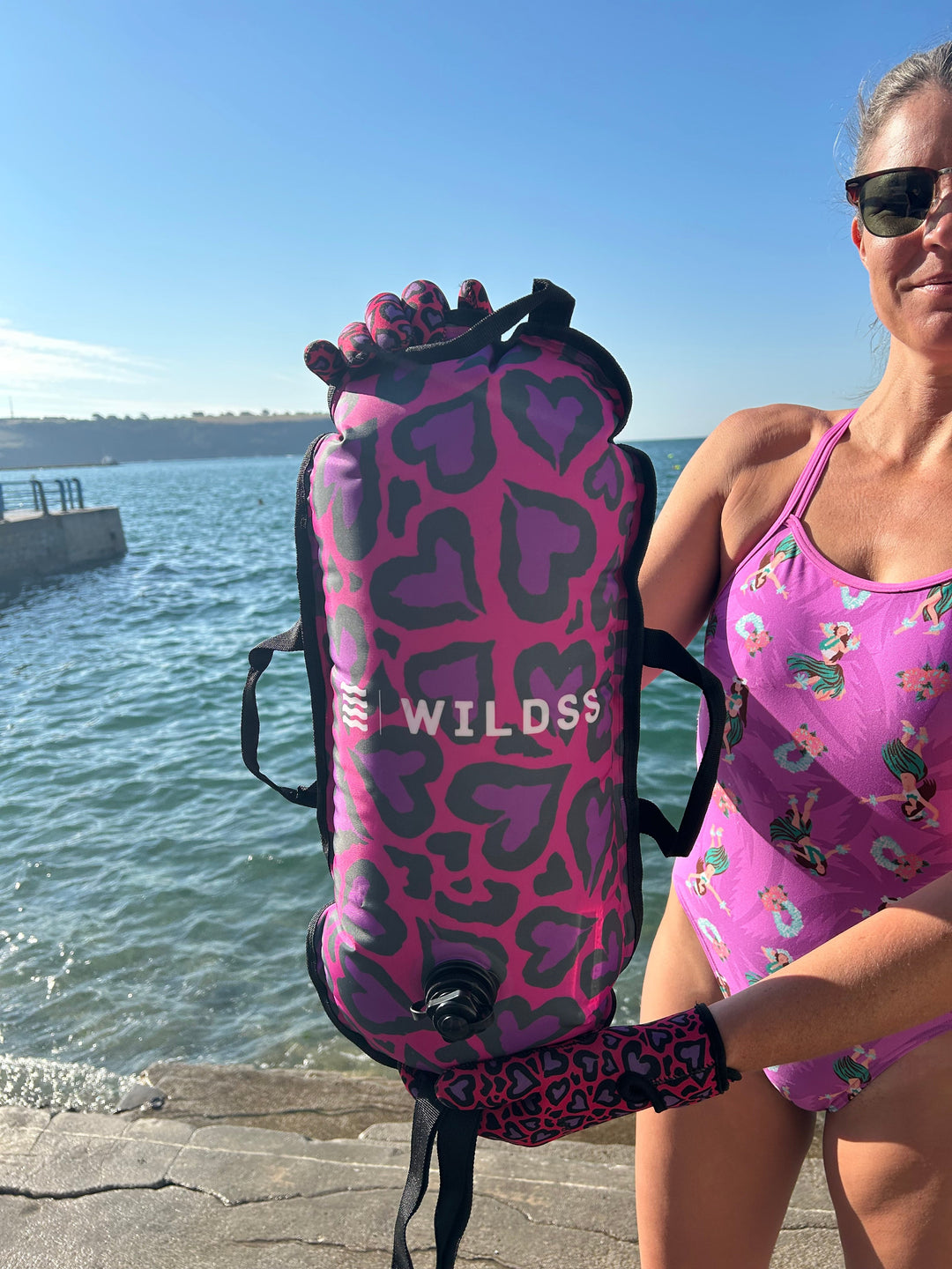 Close-up of pink Cold Cold Heart print tow float with built-in thermometer by Wild Swimming Socks.