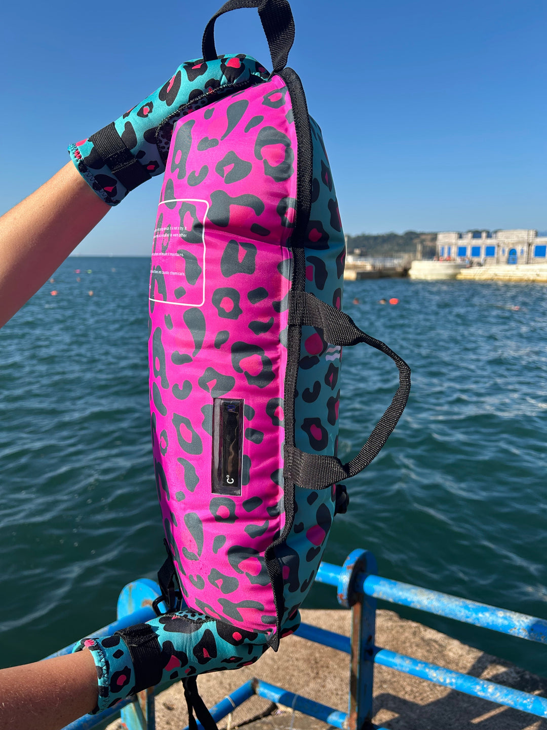 Close up of the Wild Swimming Socks dual print blue/pink leopard tow float with built-in thermometer for open water swimming.